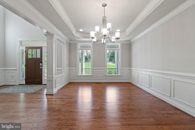 entryway featuring dark wood-type flooring, a tray ceiling, crown molding, and an inviting chandelier