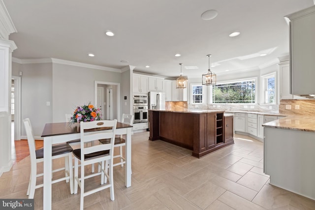 kitchen with white cabinetry, decorative light fixtures, a center island, and decorative backsplash