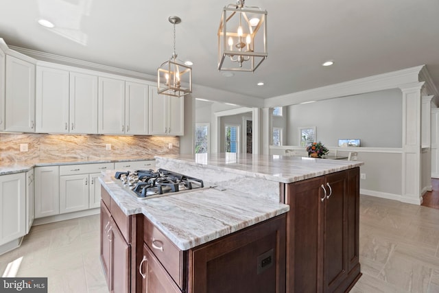 kitchen featuring dark brown cabinetry, white cabinets, stainless steel gas stovetop, and a center island