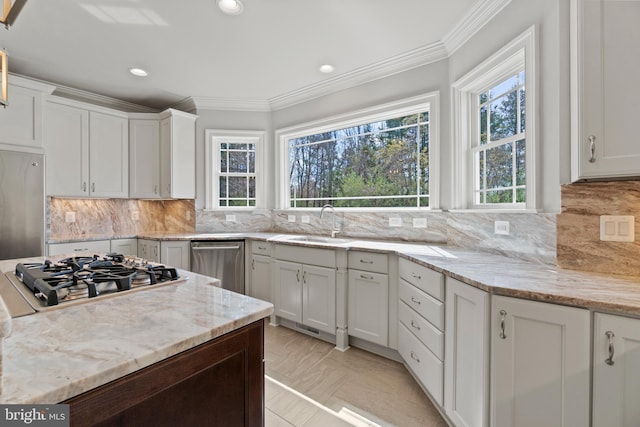 kitchen featuring sink, white cabinetry, light stone counters, and appliances with stainless steel finishes