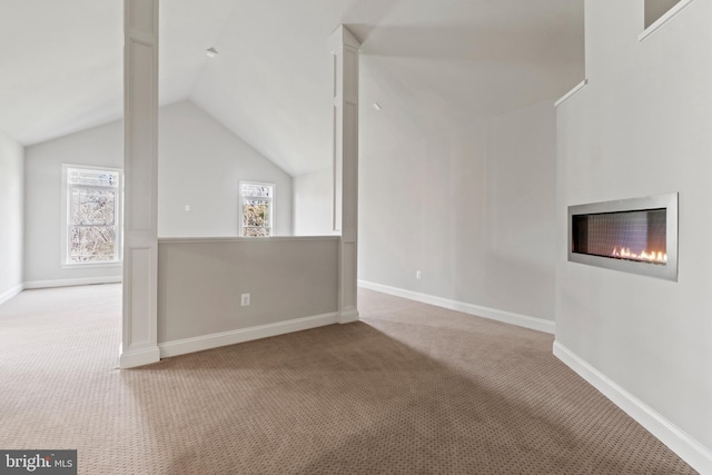 unfurnished living room with vaulted ceiling and carpet floors