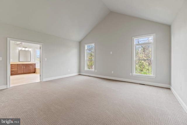 unfurnished living room with light colored carpet and vaulted ceiling