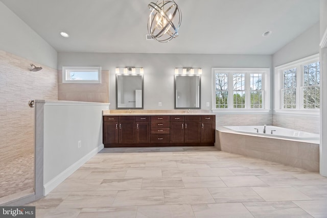 bathroom featuring vanity, independent shower and bath, an inviting chandelier, and plenty of natural light