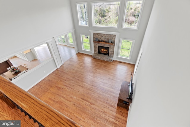 unfurnished living room with hardwood / wood-style flooring, a high ceiling, and a fireplace