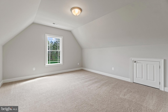 bonus room featuring vaulted ceiling and carpet