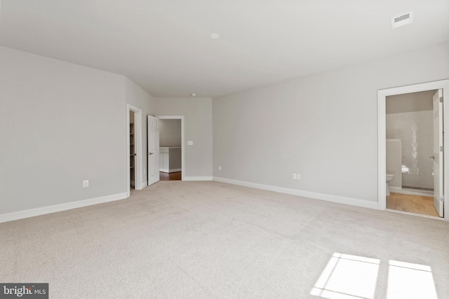 interior space with light carpet and ensuite bath