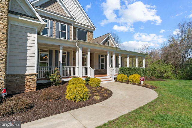 view of front of property with covered porch and a front lawn