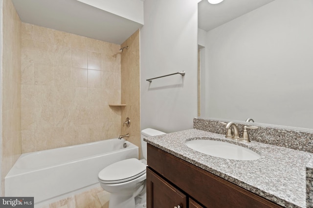 full bathroom with toilet, vanity, and tiled shower / bath