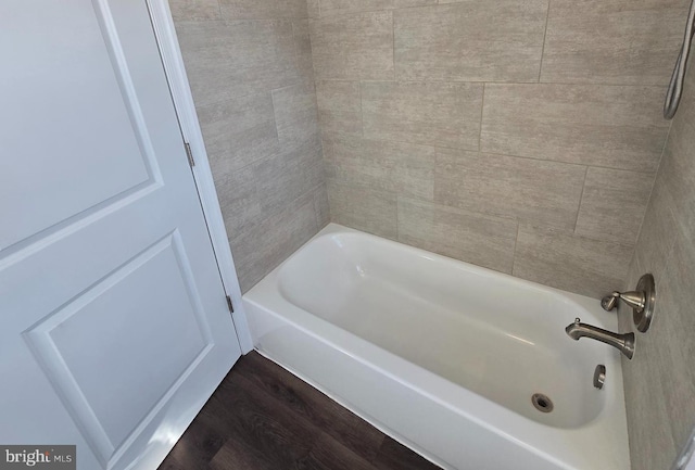 bathroom with shower / washtub combination and hardwood / wood-style flooring