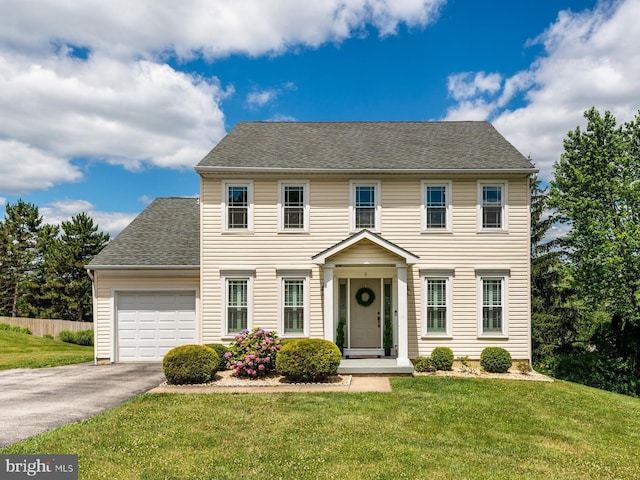 colonial-style house with a garage and a front lawn