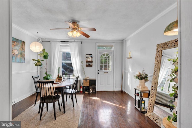 dining room featuring ceiling fan, ornamental molding, dark hardwood / wood-style floors, and a textured ceiling