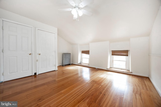 bonus room featuring ceiling fan, lofted ceiling, radiator, and light hardwood / wood-style floors