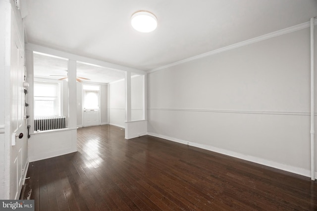 unfurnished room with dark wood-type flooring, ceiling fan, radiator heating unit, and crown molding