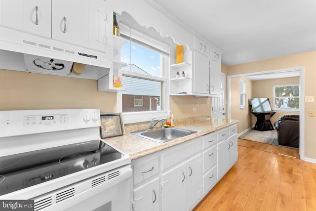 kitchen with sink, white cabinets, light wood-type flooring, and electric stove