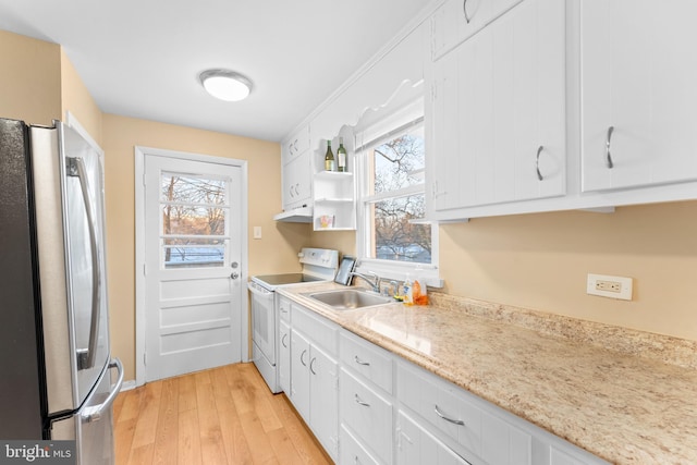 kitchen featuring stainless steel refrigerator, white range with electric cooktop, white cabinetry, and sink