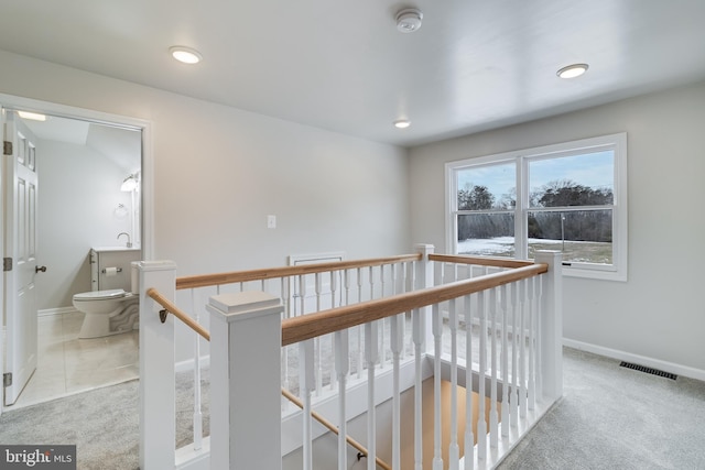 hallway featuring sink and light colored carpet