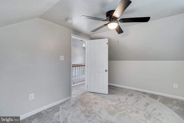 additional living space featuring vaulted ceiling, light colored carpet, and ceiling fan