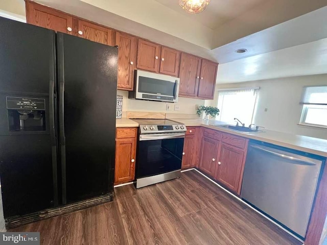 kitchen with stainless steel appliances, dark hardwood / wood-style flooring, and sink