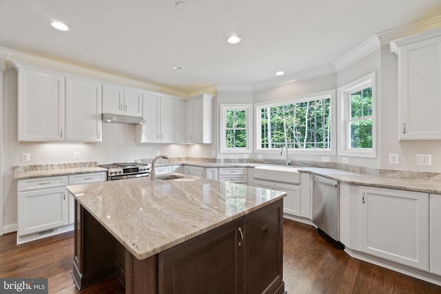 kitchen with stainless steel appliances, white cabinetry, and a center island with sink