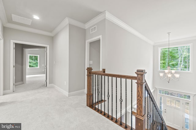 hall with crown molding, light carpet, and a notable chandelier