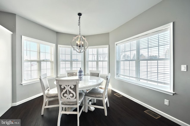 dining area with dark hardwood / wood-style floors and a chandelier