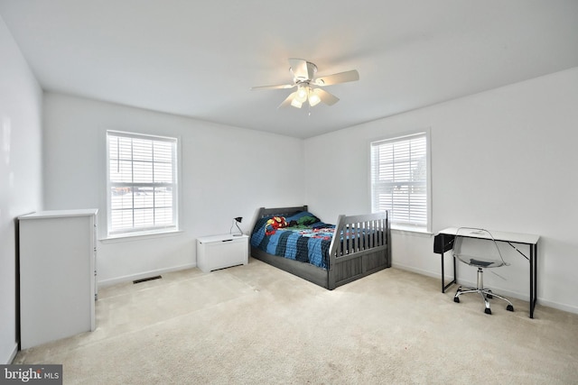 carpeted bedroom featuring ceiling fan and multiple windows