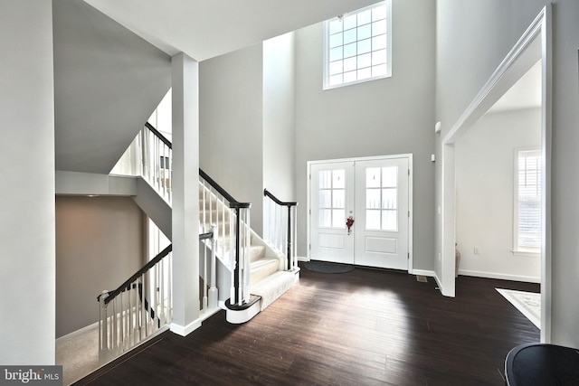 entrance foyer with a high ceiling, dark hardwood / wood-style floors, plenty of natural light, and french doors