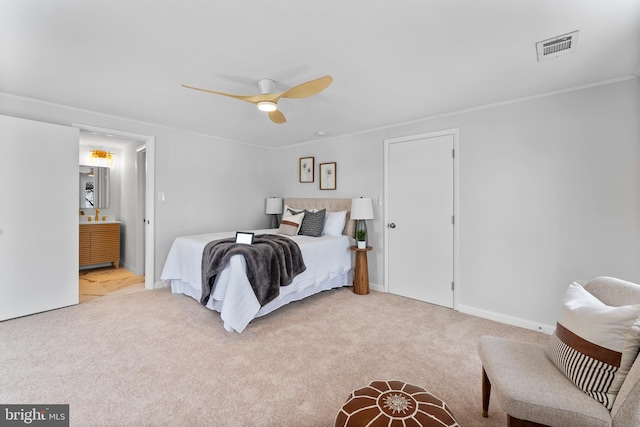 bedroom with ceiling fan, ensuite bath, crown molding, and light carpet