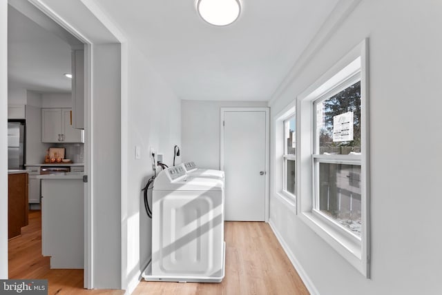 laundry room featuring light hardwood / wood-style floors and washing machine and dryer