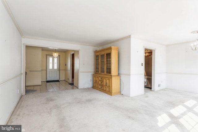 carpeted spare room featuring crown molding and an inviting chandelier