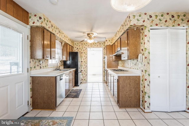 kitchen featuring sink, stainless steel dishwasher, light tile patterned floors, ceiling fan, and gas stovetop