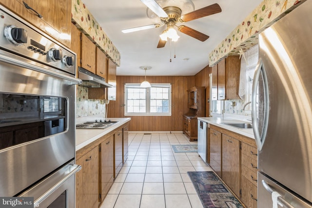 kitchen featuring sink, hanging light fixtures, light tile patterned floors, ceiling fan, and stainless steel appliances