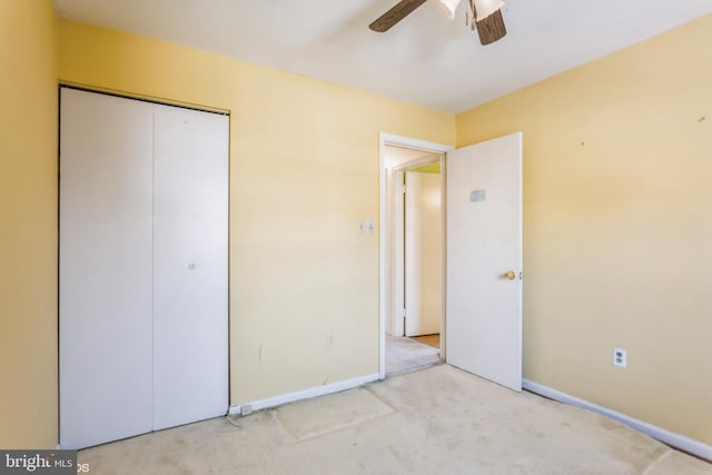 unfurnished bedroom featuring light colored carpet, a closet, and ceiling fan