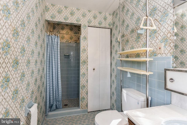 bathroom with a shower with curtain, tile patterned flooring, tile walls, and toilet