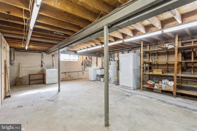 basement with washer / clothes dryer, sink, white fridge, and gas water heater