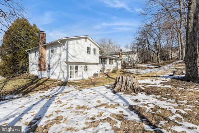 snow covered rear of property featuring french doors