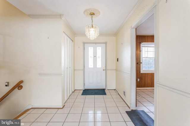 entrance foyer featuring light tile patterned flooring, ornamental molding, wooden walls, and a chandelier