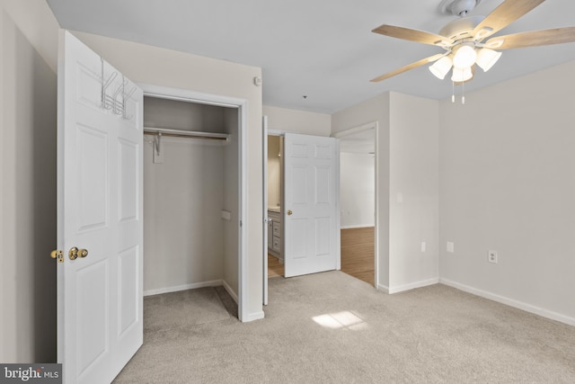 unfurnished bedroom featuring light carpet, ceiling fan, and a closet