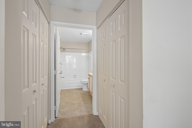 hall featuring light colored carpet