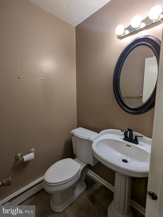 bathroom with baseboard heating, toilet, and a textured ceiling