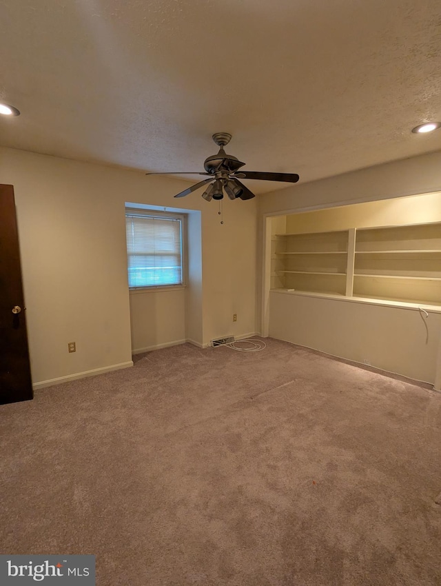 carpeted empty room featuring a textured ceiling and ceiling fan