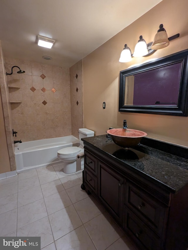 full bathroom featuring tile patterned flooring, vanity, tiled shower / bath, and toilet