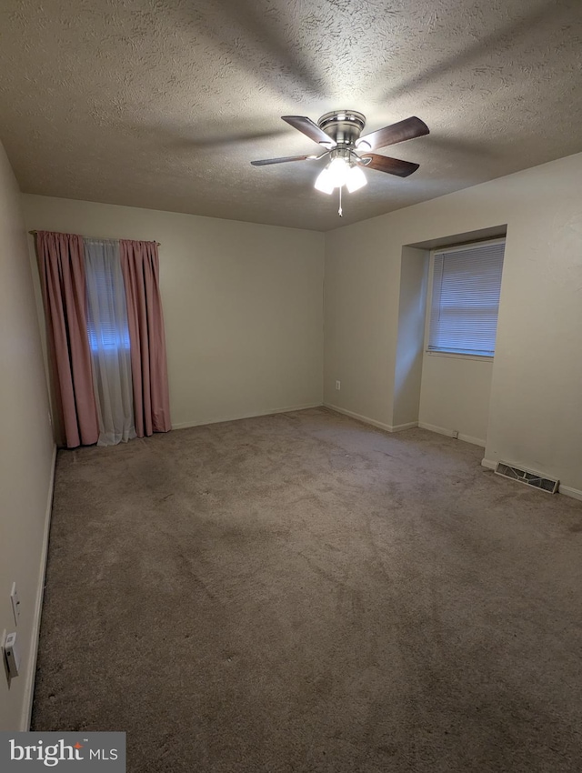 spare room with ceiling fan, carpet flooring, and a textured ceiling