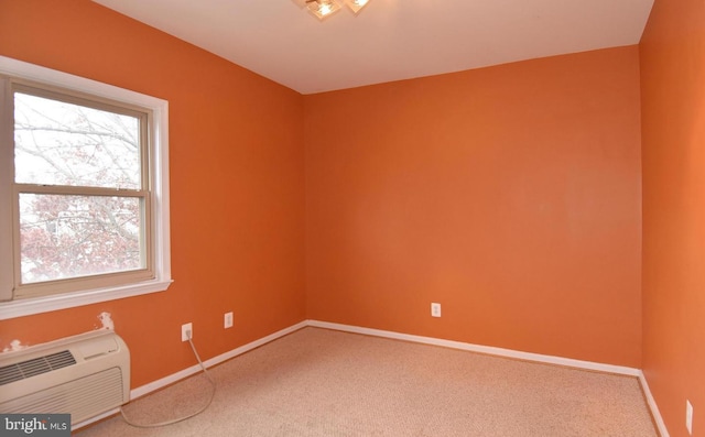 carpeted spare room featuring a wall unit AC