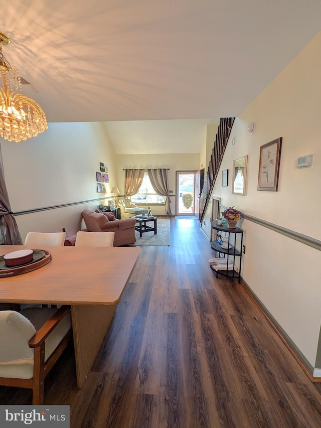 living room featuring dark hardwood / wood-style floors, lofted ceiling, and a notable chandelier