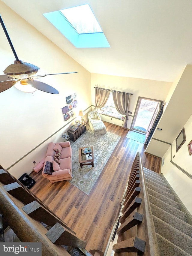 living room with hardwood / wood-style floors and lofted ceiling with skylight