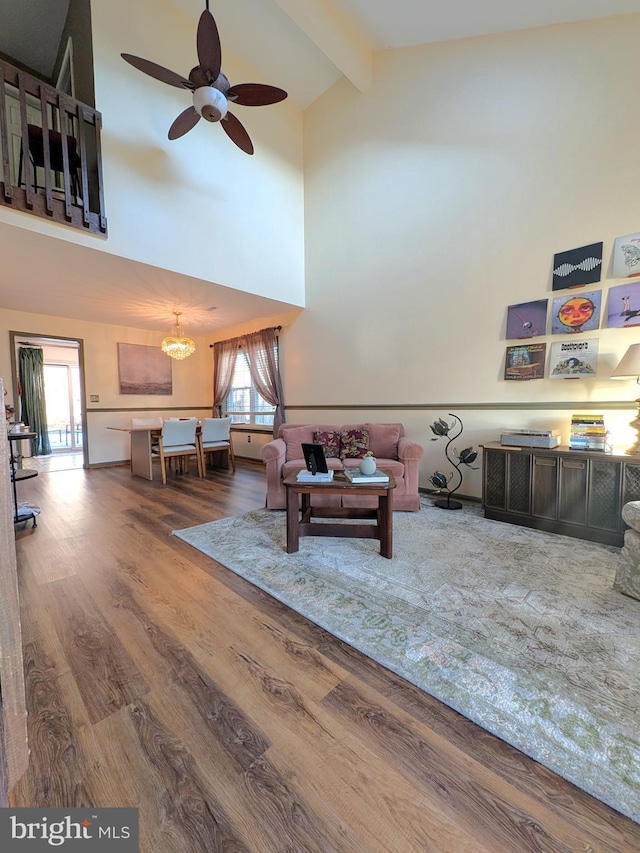 living room with hardwood / wood-style flooring, beam ceiling, high vaulted ceiling, and a healthy amount of sunlight