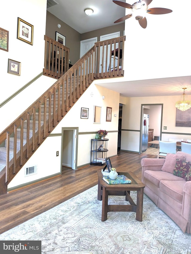 living room featuring ceiling fan with notable chandelier and wood-type flooring