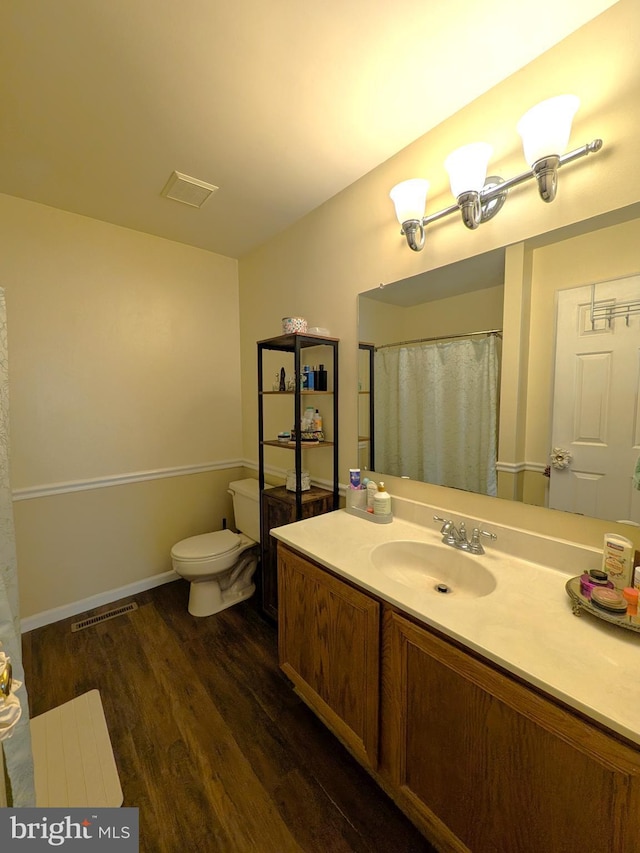 bathroom with hardwood / wood-style floors, toilet, and vanity