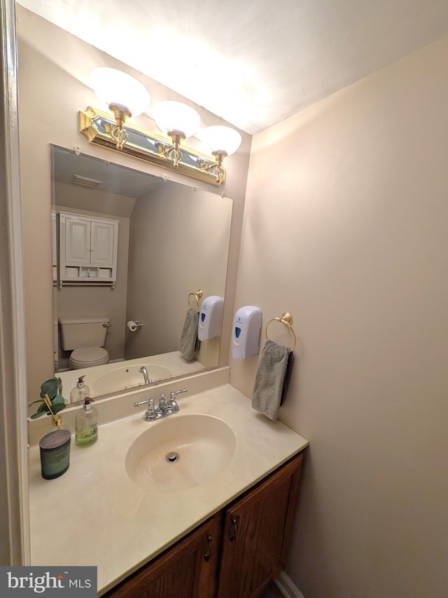 bathroom featuring toilet and vanity